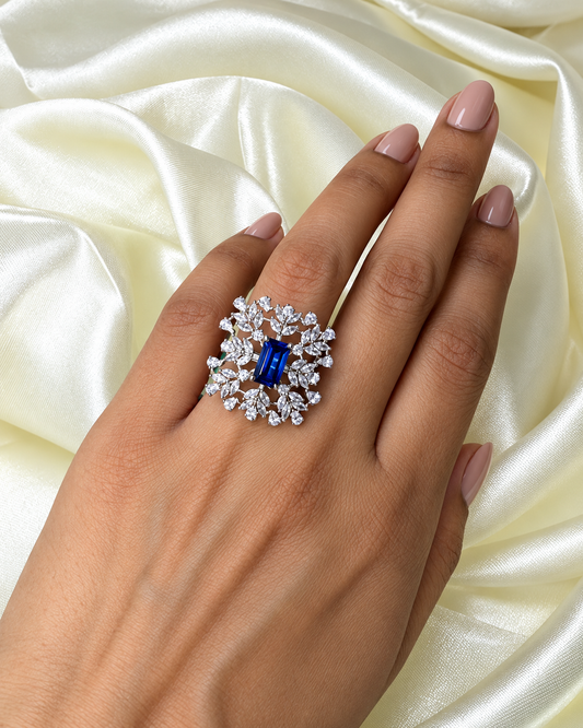 Sapphire Snowflake Cocktail Ring with a blue centre and white leaf-shaped stones worn on a hand
