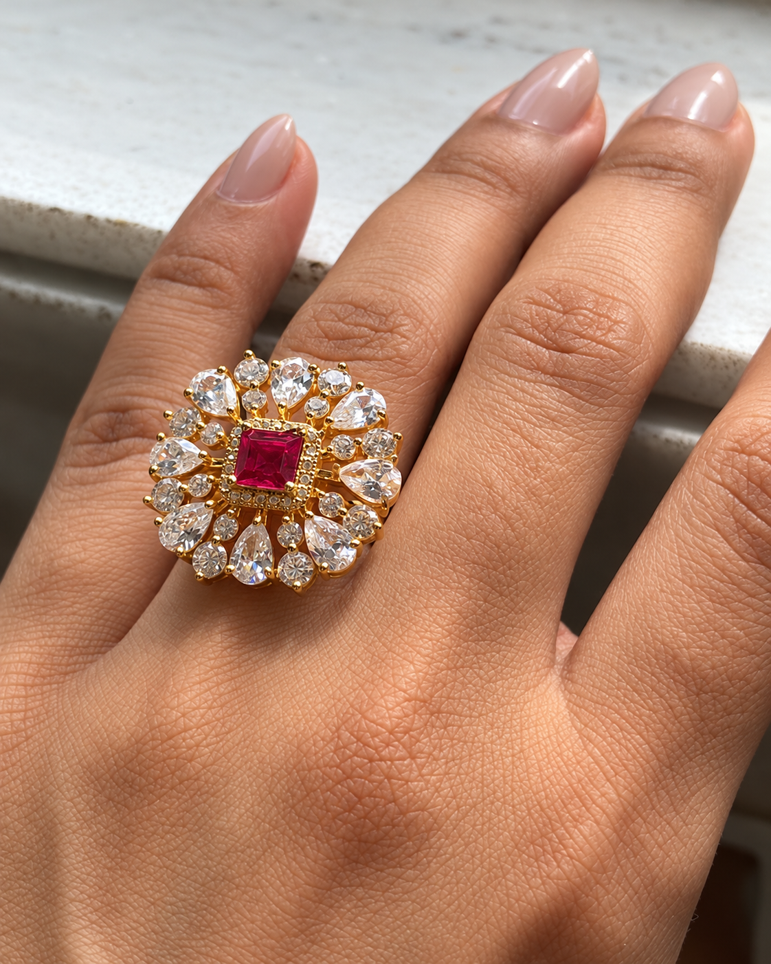 Close-up of adjustable red onyx floral cocktail ring worn on a finger